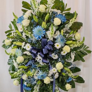 Funeral arrangement of blue and white flowers